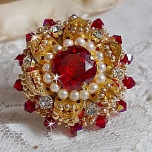 Bague L’Oiseau des Iles Rouge Doré avec un cabochon Rouge sur une estampe dorée ornée de cristaux : toupies et chatons. Les perles rondes nacrées Ivoire et Rouge complètent cette bague réglable Dorée